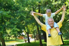 happy grandfather and child have fun and play in park