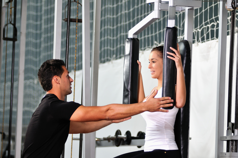 woman in the fitness gim working out with personal trainer coach